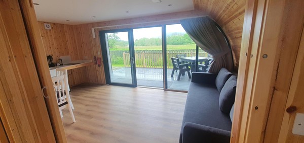 Image of the living room area from the bedroom side of the accessible glamping pod.