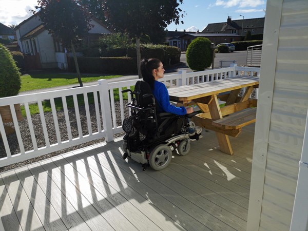 Wheelchair accessible picnic table on caravan decking.