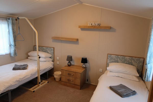 Bedroom with portable helper frame over the bed.