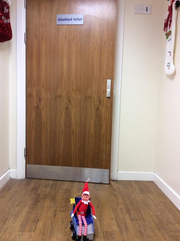 Alfie the Elf outside a toilet with the sign saying "disabled toilet".