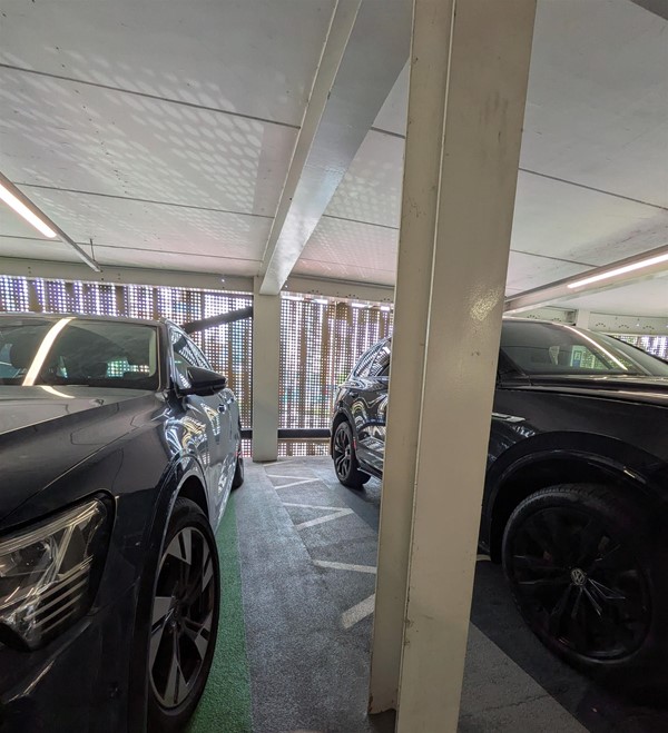image of space at the side of the row of parking spaces with electric vehicle charging points