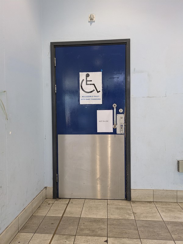 Image of acces to the accessible toilet - as sign is taped to the door advising 'NOT IN USE'