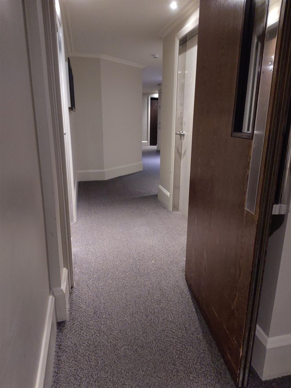 Narrowish doorway in corridor near the room.