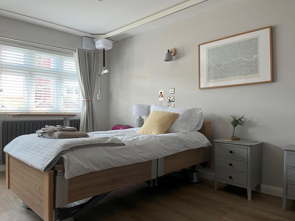 Image of one of the hospital beds and the tracking hoists in the accessible bedroom.
