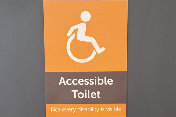 Accessible loo sign that reads "Not every disability is visible"