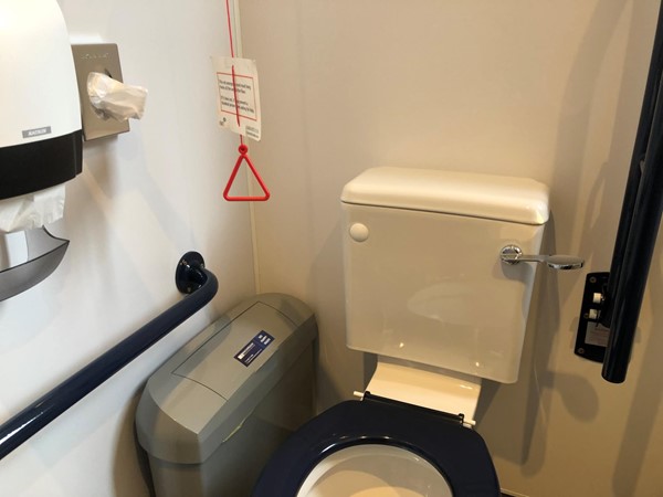 Accessible toilet. Red Cord Card, but cord not hanging to the floor.