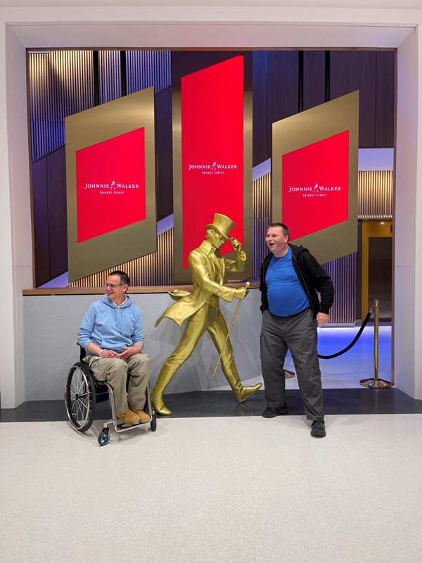 A photo of myself and my pal in front of the enormous golden Running Man statue in the entrance hallway