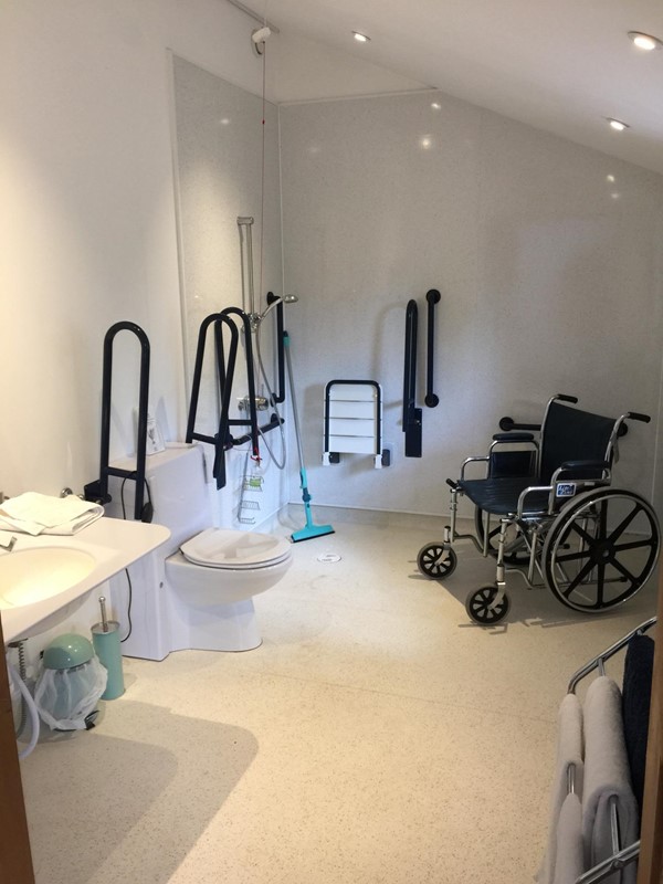 Easy to use wet room with drop down rails either side of the toilet, rise and fall sink and mirror, and kindly provided shower chair.