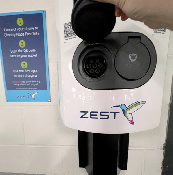 Image of charging point and connector with signage with instructions